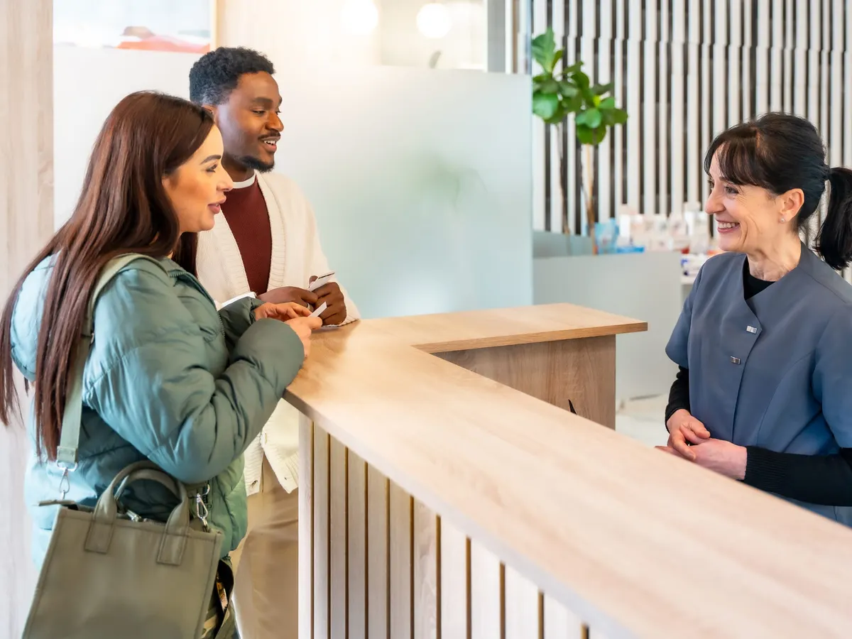 Patients checking in at a clinic reception desk