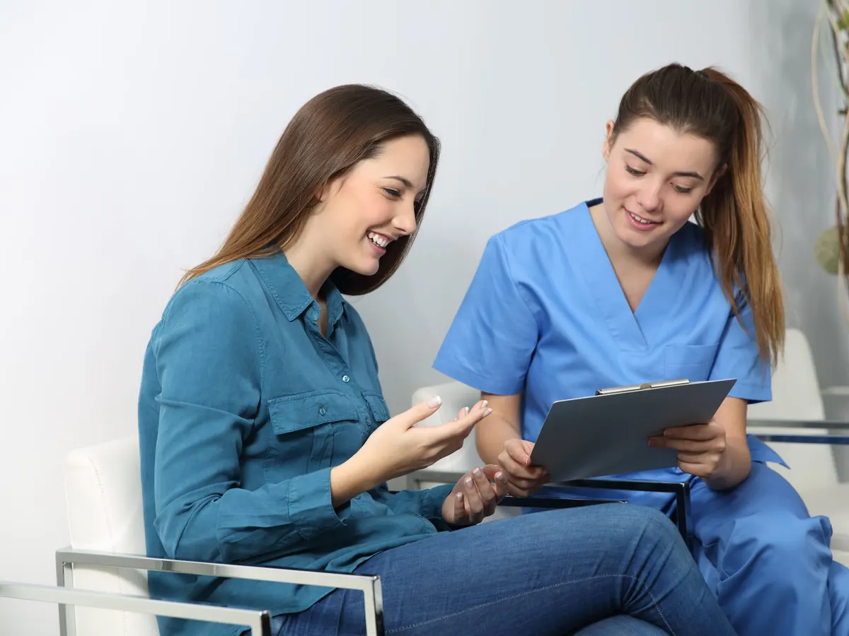 A nurse going over information with a patient on a tablet
