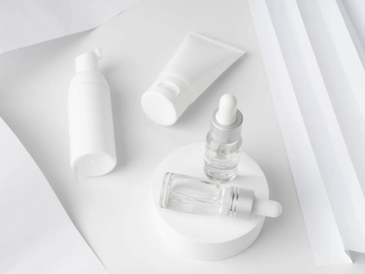 Skincare bottles and tubes on a white surface