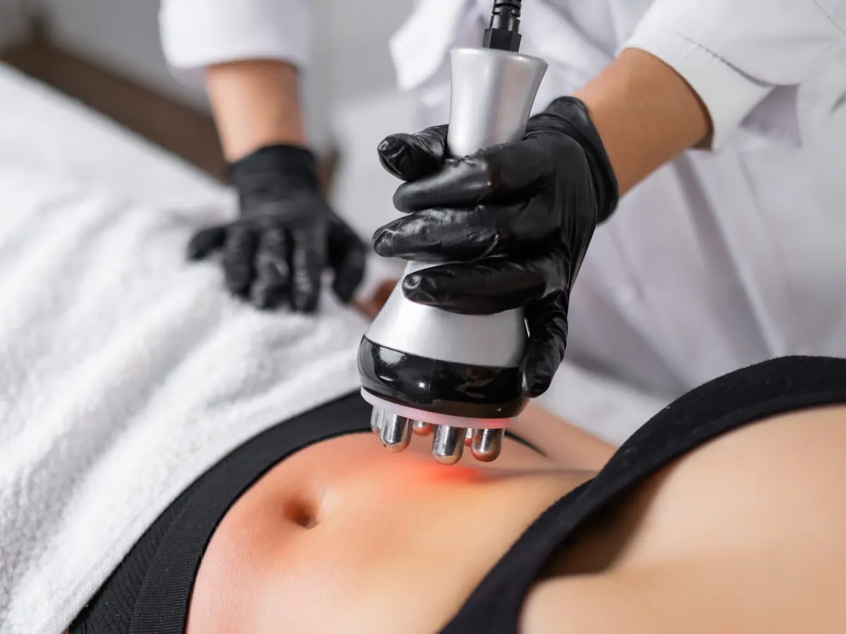 A provider uses a handheld treatment device on a patient’s abdomen