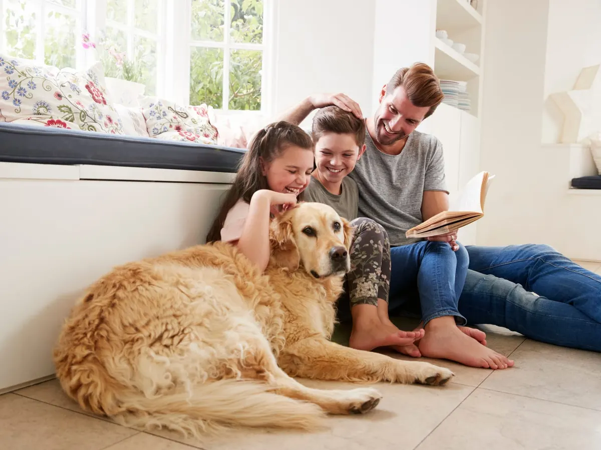 Father Reading Book With Son And Daughter And Pet Dog
