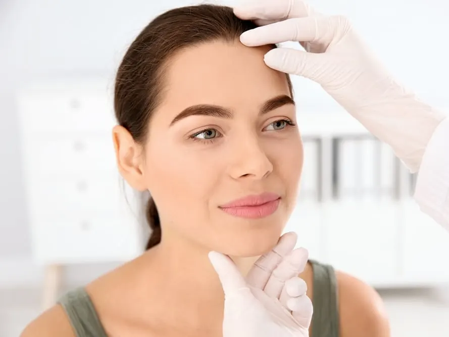 A dermatologist examining a woman's skin to suggest age reversal treatments for 2025
