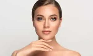 A woman touching her chin showing the results of JUVÉDERM® in San Antonio