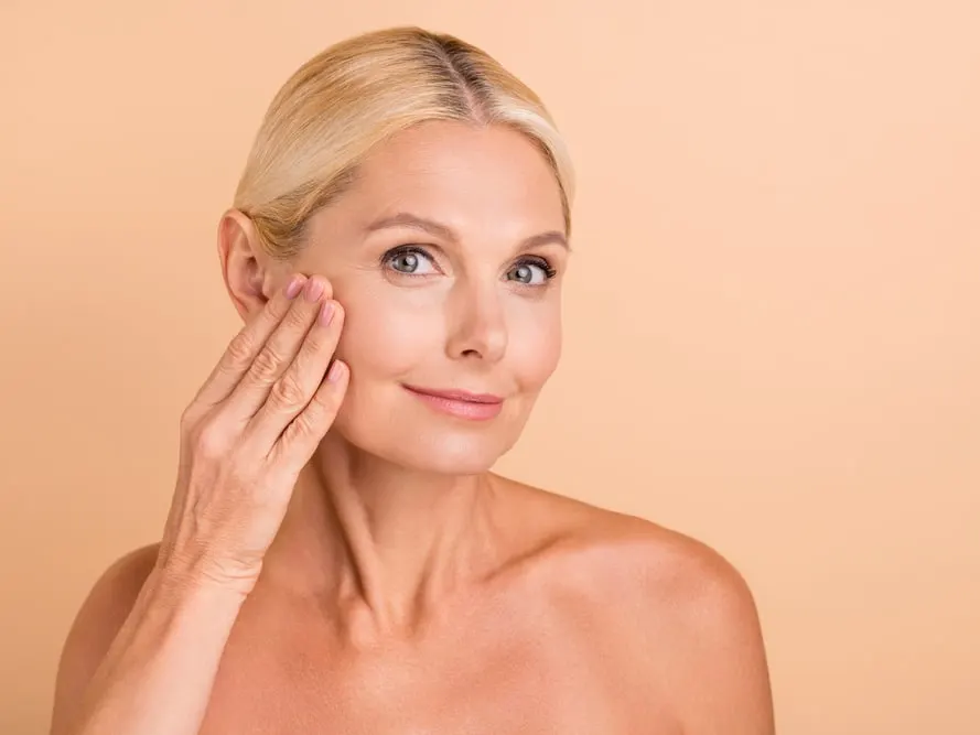 A woman touching her cheek after a liquid facelift in San Antonio