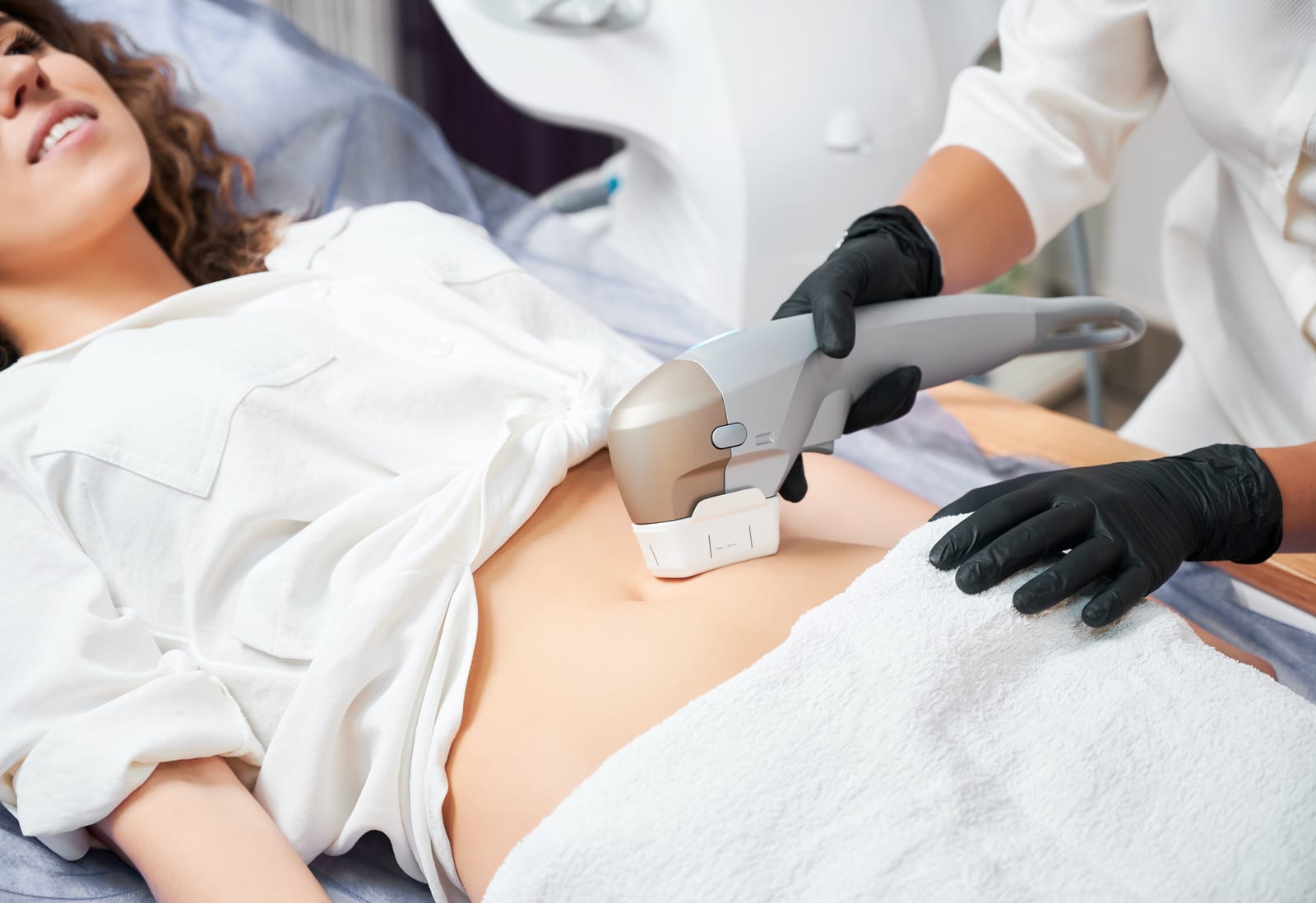 A patient receives a non-invasive fat-reduction treatment on her abdomen