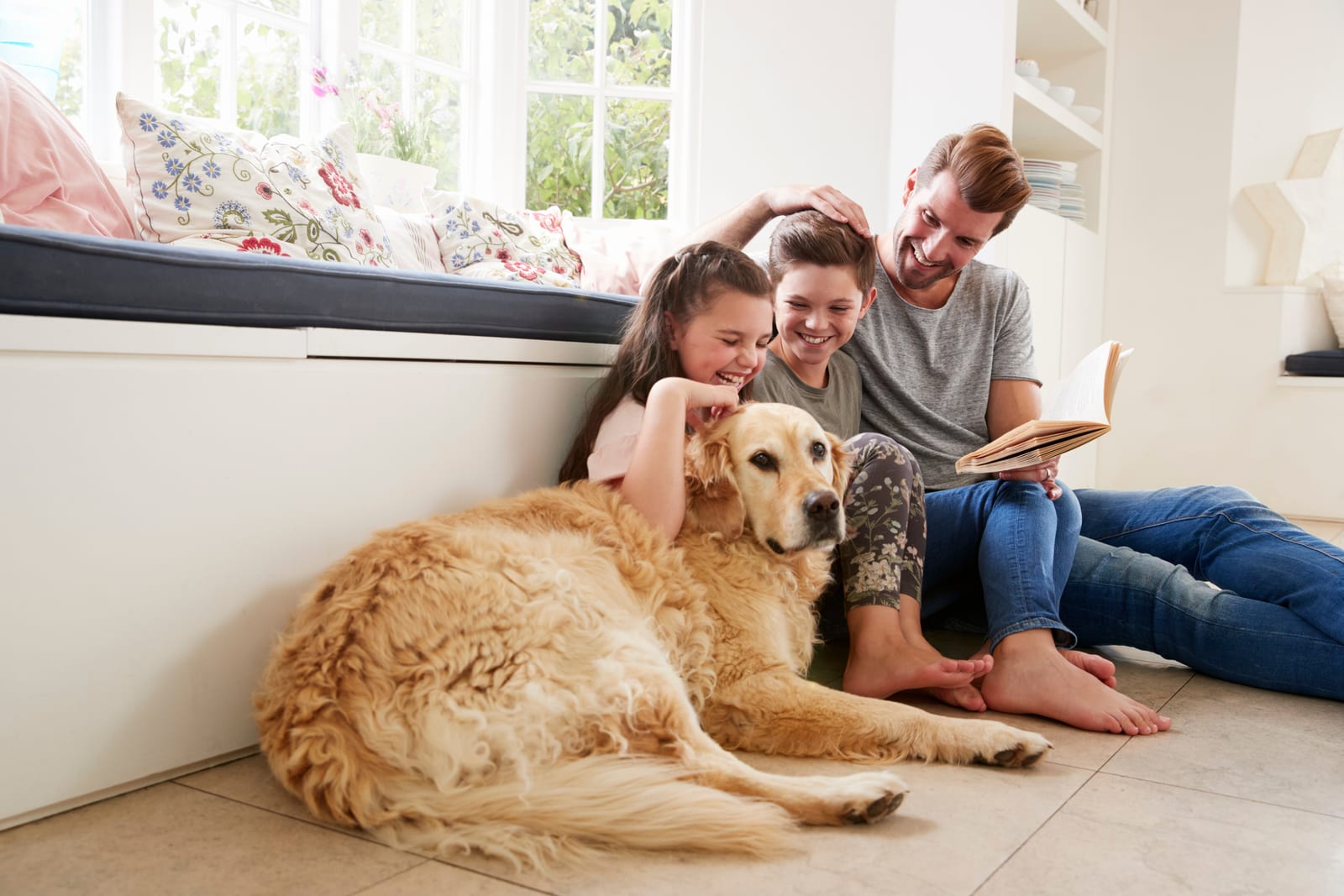 Father Reading Book With Son And Daughter And Pet Dog