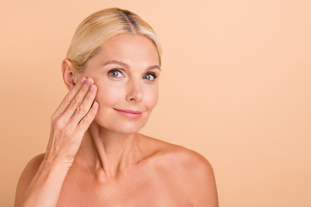A woman touching her cheek after a liquid facelift in San Antonio