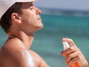 man at the beach applying protective cream