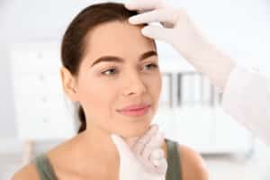 A dermatologist examining a woman's skin to suggest age reversal treatments for 2025